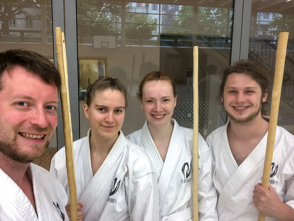 Vier Personen mit Kobudo Holzstäben (Bo).