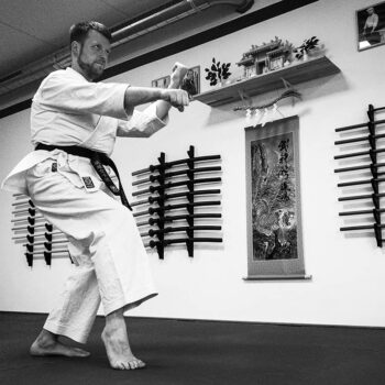 Karatelehrer demonstriert eine Technik aus einer Kata in einem Kampfsport Dojo.