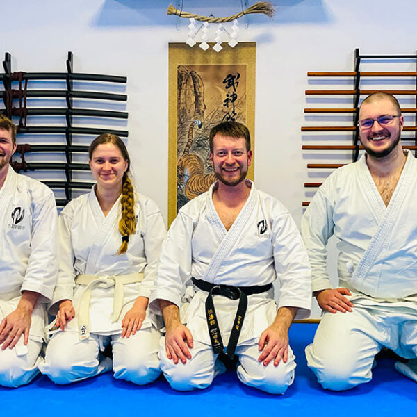 Vier Personen sitzen nach dem letzten Karate Training des Jahres auf dem Bodem im Dojo.