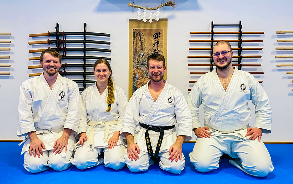 Vier Personen sitzen nach dem letzten Karate Training des Jahres auf dem Bodem im Dojo.
